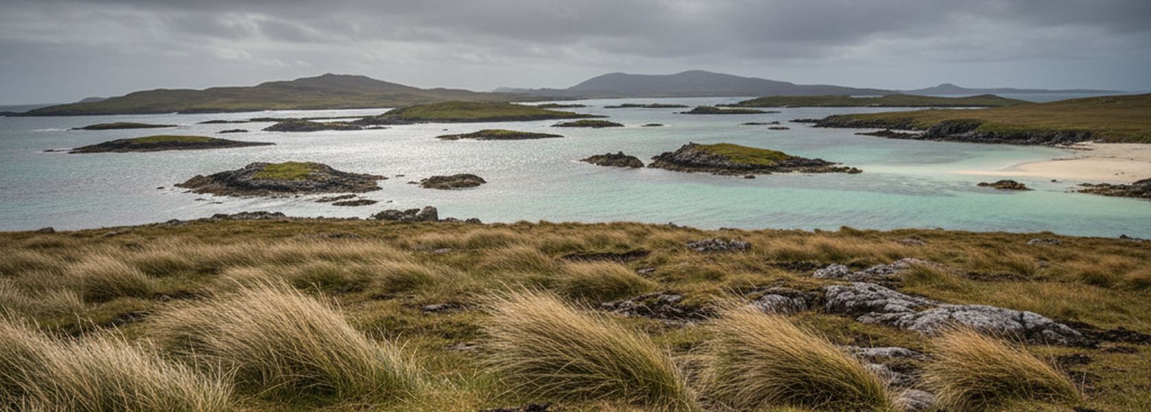 Shallow tidal sound between low Hebridean islands, pale sand shelves showing green through the water under broken cloud.